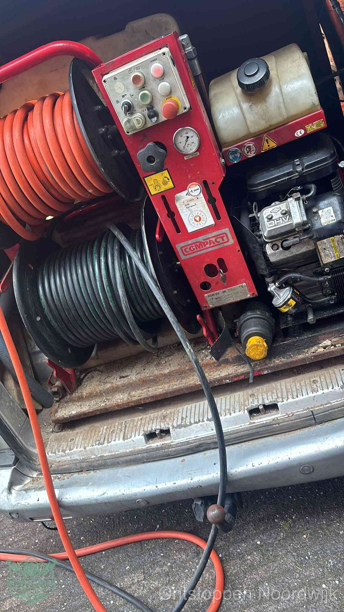Een rood hogedruk-rioolreinigingstoestel in de laadbak van de bedrijfsbus, apparatuur voor een hardnekkige afvoerverstopping in Noordwijk