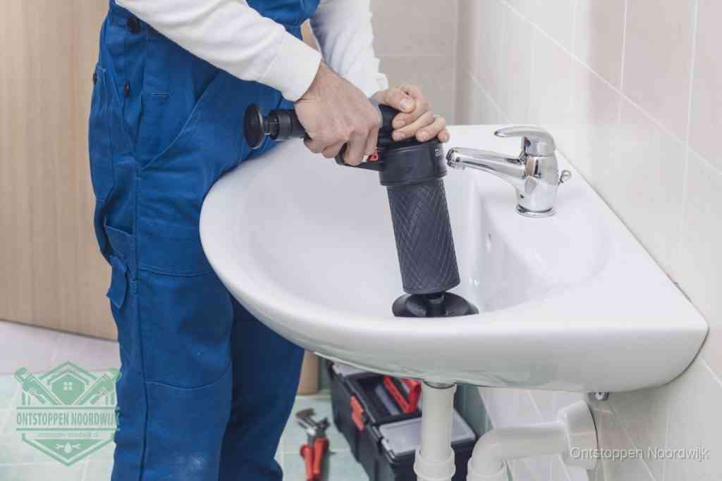 Een te ruwe doe-het-zelf poging met een hand-pomp op de afvoer van een badkamer-wastafel, een van de veelgemaakte fouten bij afvoer ontstoppen in Noordwijk